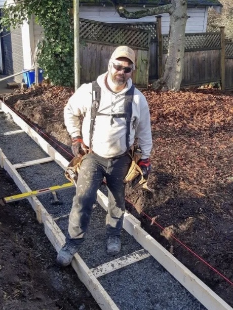Man working on concrete sidewalk construction.